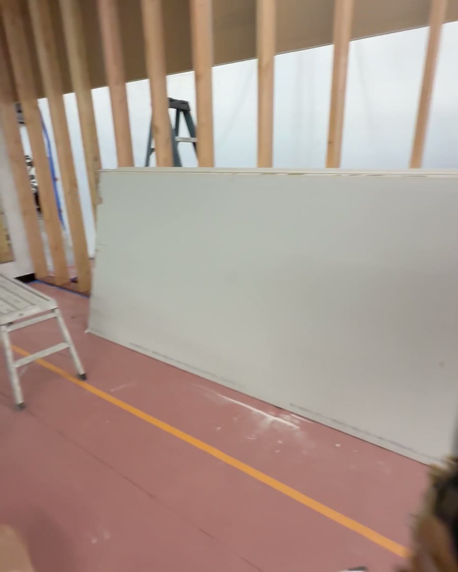 The same area during framing: open wood studs on the gym floor