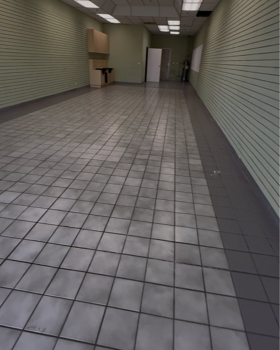 The same suite before: an empty shell with old tile floor and drop ceiling