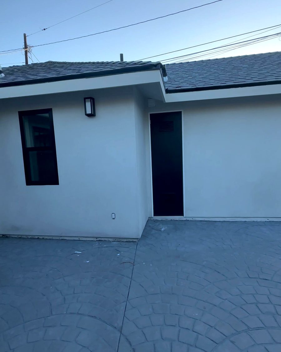 Finished: the new white stucco ADU with stamped concrete patio