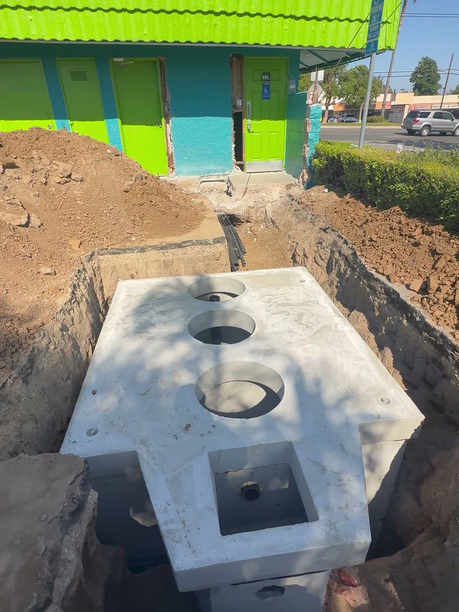 Precast grease interceptor set in an excavation beside a restaurant