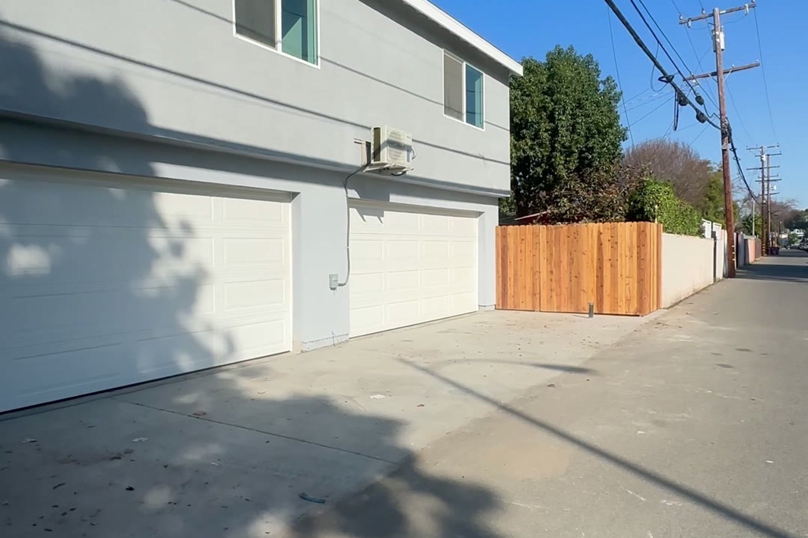 Finished: stucco exterior with two roll-up garage doors on the alley